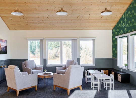 a living room with chairs and tables and a wooden ceiling