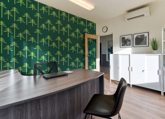 a office with a green wall and a desk with a chair