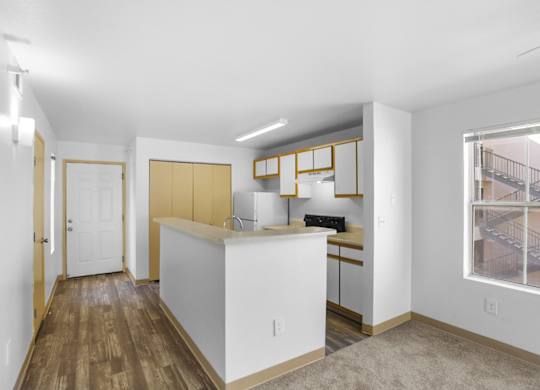 A kitchen with white cabinets and a wooden floor.