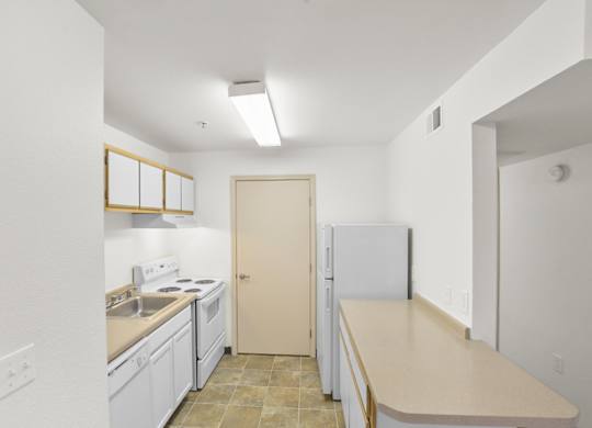 A kitchen with white cabinets and a beige countertop.