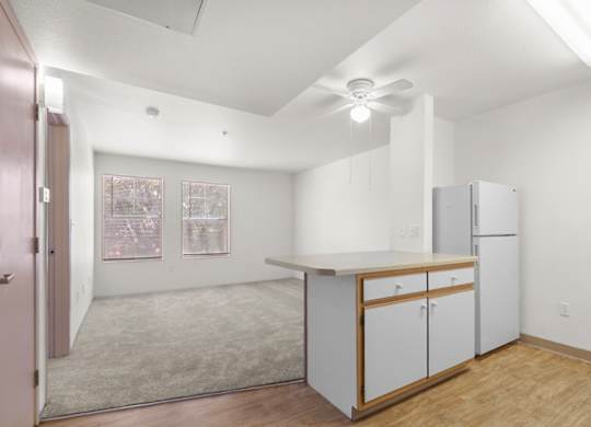 A kitchen with white cabinets and a ceiling fan.