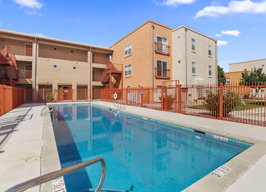 A swimming pool in front of apartment buildings.