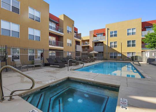 A swimming pool in front of apartment buildings.