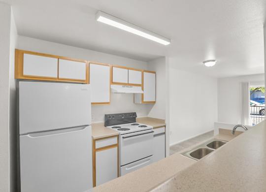 A kitchen with white appliances and wooden accents.