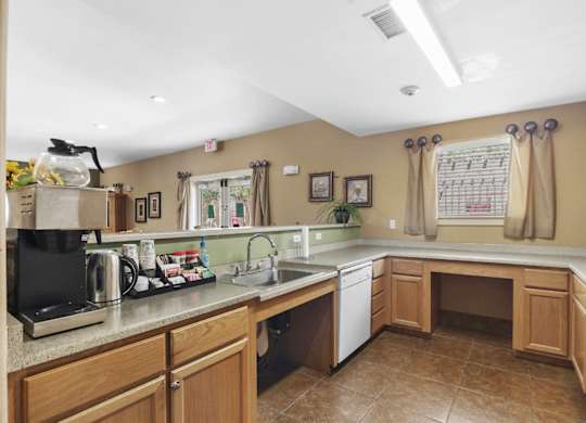 A kitchen with brown cabinets and a black coffee maker.