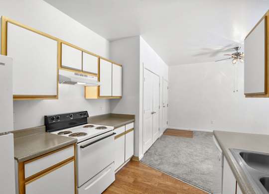 A kitchen with white cabinets and a black stove top.