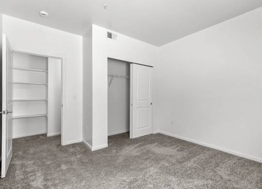 A room with a carpeted floor and white walls.