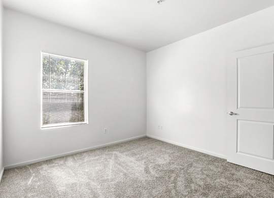 A white room with a door and a window.