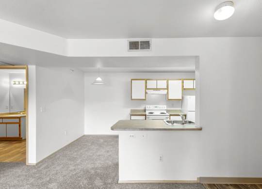 A kitchen with white cabinets and a window above the counter.