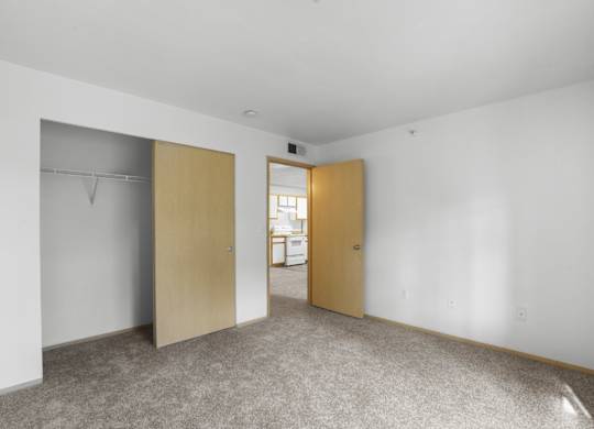 A room with a carpeted floor and two closed doors.