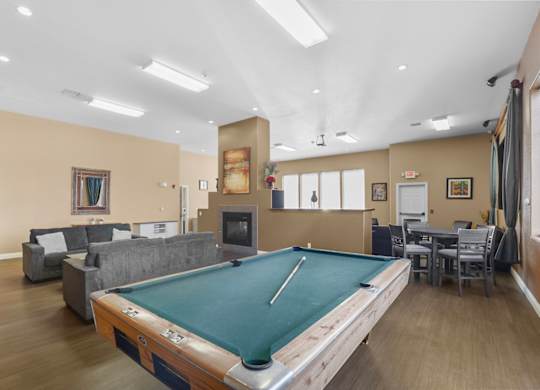 A room with a pool table and a fireplace.