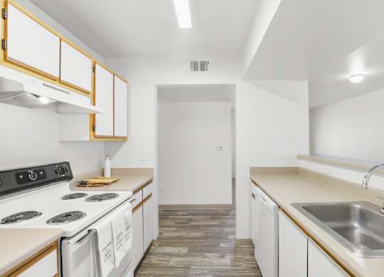 A kitchen with white cabinets and a black stove top.