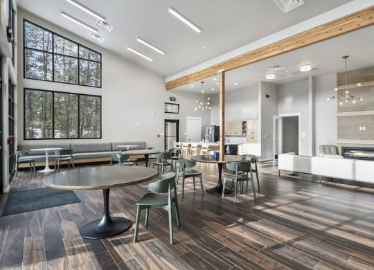 a communal area with tables and chairs and a living room with a fireplace