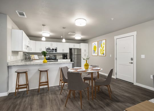 our apartments offer a kitchen and dining area with a table and chairs