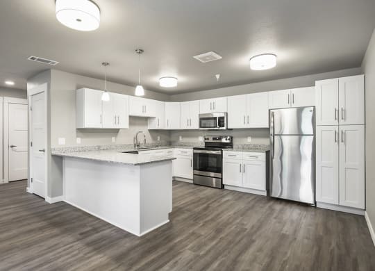 a large kitchen with white cabinets and stainless steel appliances