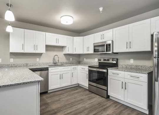 a large kitchen with white cabinets and stainless steel appliances