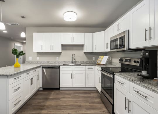 an empty kitchen with white cabinets and stainless steel appliances