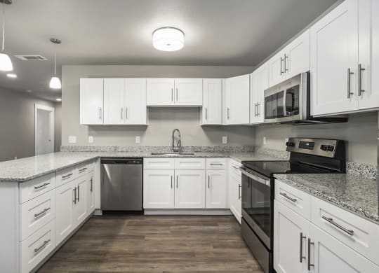 a large kitchen with white cabinets and stainless steel appliances