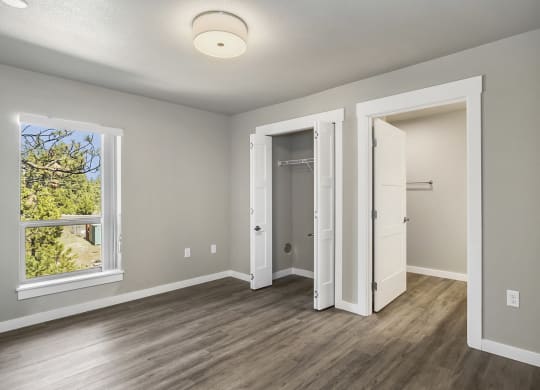 a bedroom with hardwood floors and grey walls