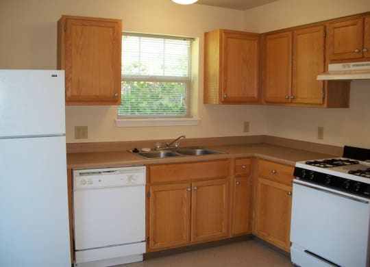 a kitchen with white appliances and wooden cabinets