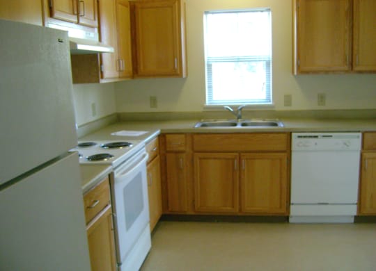 a kitchen with white appliances and wooden cabinets