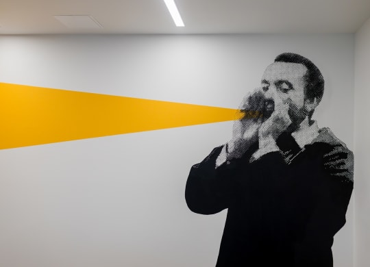 a mural of a man smoking a      on a white wall