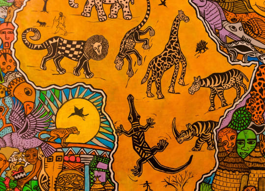 a close up of an orange cloth with various animals on it