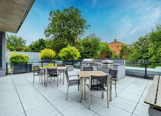 A patio with a table and chairs overlooking a garden.