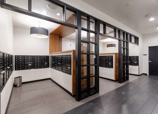 A modern office lobby with black and white decor and a trash can.