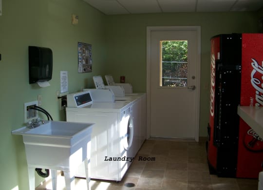 a laundry room with a coke machine and a sink