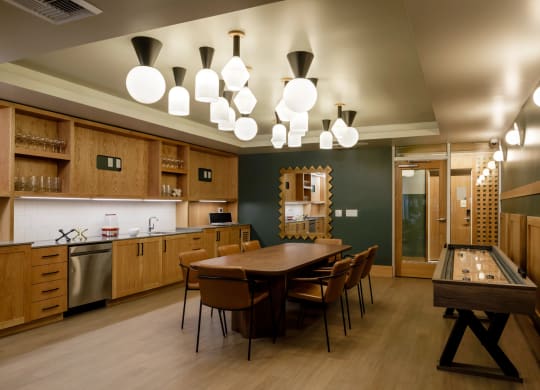 a game room with a long table and a shuffleboard table at Slabtown Square Apartments, Portland 