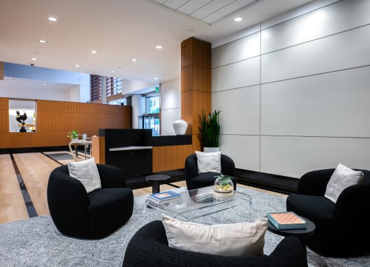 a living room with black chairs and a glass coffee table
