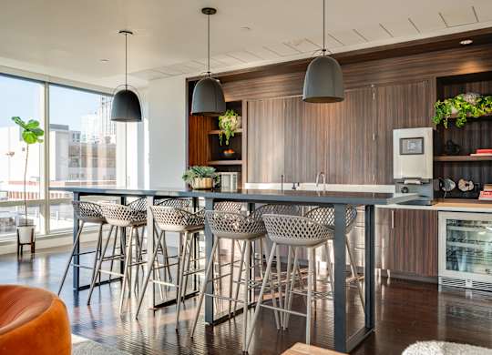 A modern kitchen with a bar area and chairs.