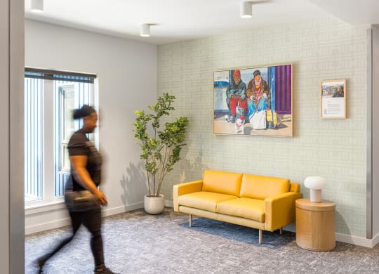 a person walking through a living room with a yellow couch
