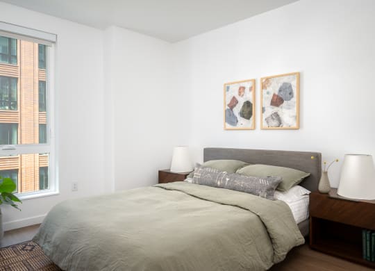 a bedroom with a large bed and two paintings on the wall at Slabtown Square Apartments, Portland 