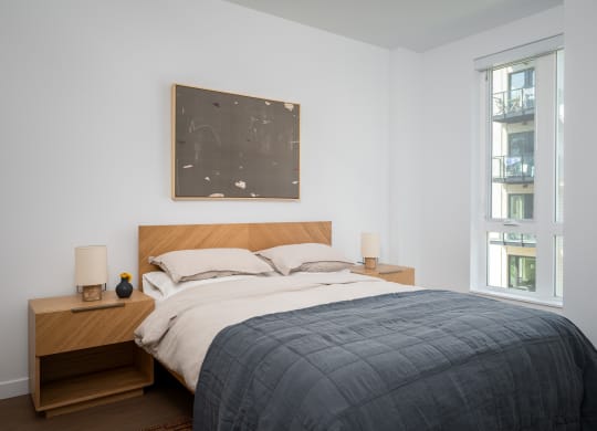 a bedroom with a bed and a painting on the wall at Slabtown Square Apartments, Portland , OR 97209