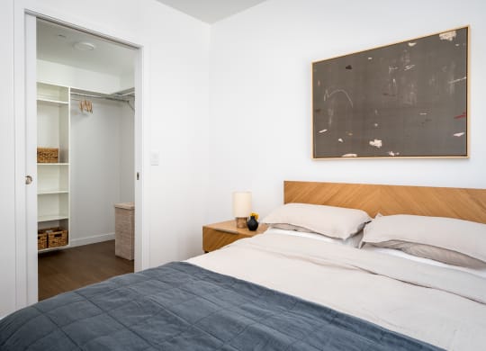 a bedroom with a bed and a painting on the wall at Slabtown Square Apartments, Portland , OR