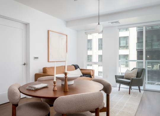 a living room with a table and chairs and a large window at Slabtown Square Apartments, Portland , Oregon