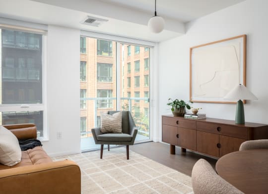 a living room with a couch and a chair and a large window at Slabtown Square Apartments, Oregon, 97209