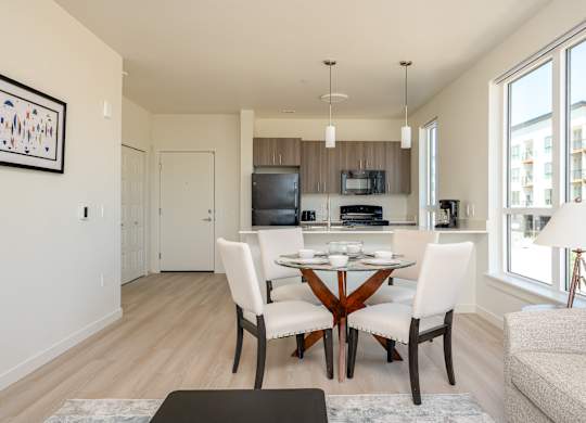 A modern kitchen with a dining table set for two.