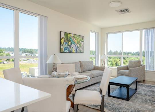 A modern living room with a dining table and chairs.
