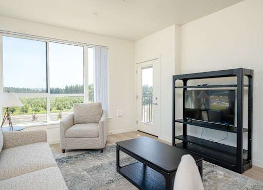 A living room with a black coffee table and a white chair.