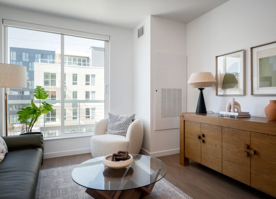 a living room with a large window and a coffee table at Slabtown Square Apartments, Portland , Oregon