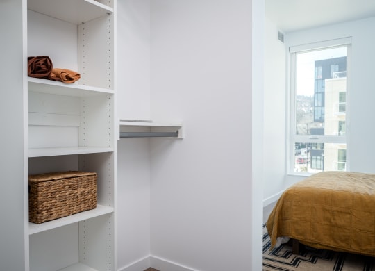 a bedroom with a bed and a closet with shelves and a window at Slabtown Square Apartments, Portland ,Oregon, 97209
