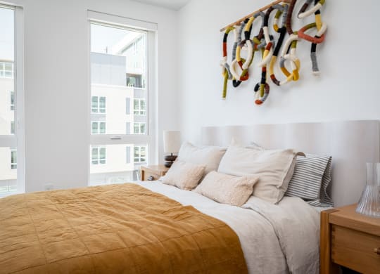 a bedroom with a bed and a large window at Slabtown Square Apartments, Oregon