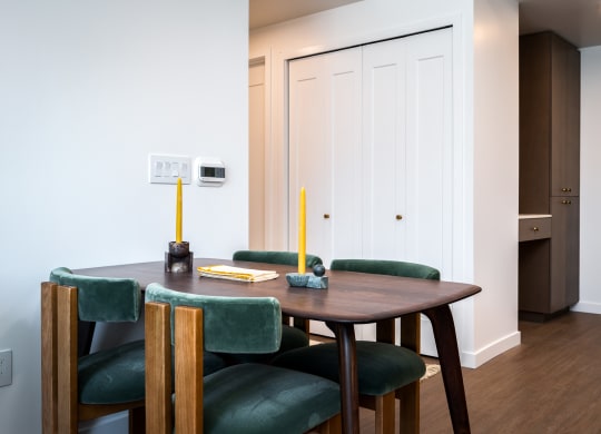a dining room with a wooden table and green chairs at Slabtown Square Apartments, Oregon, 97209