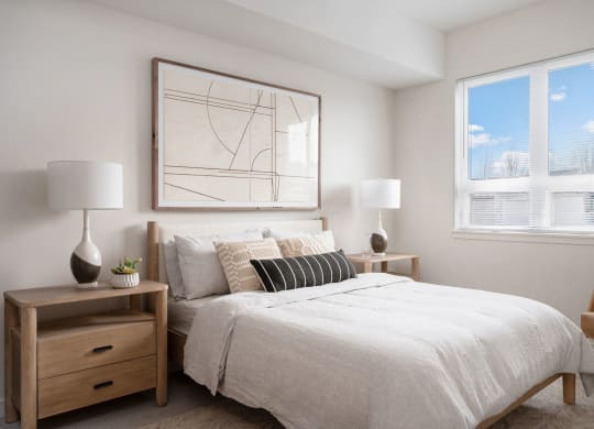 a bedroom with a large bed and two windows