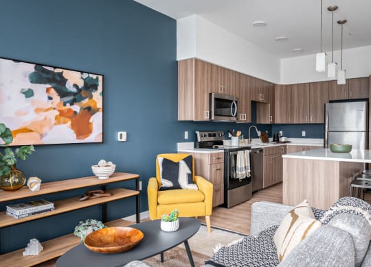 a living room and kitchen with blue walls and a yellow chair