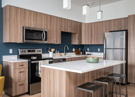 a kitchen with a large island and stainless steel appliances