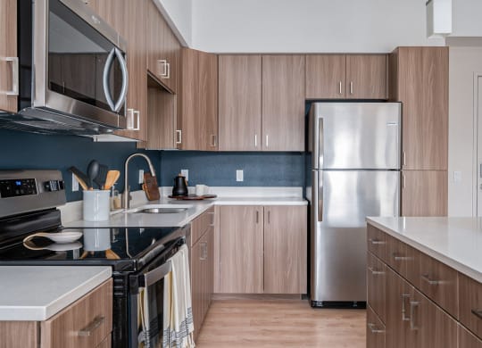 a kitchen with wooden cabinets and a stainless steel refrigerator